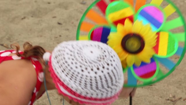 Toy with sunflower in center is set in ground, then girl took it