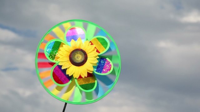Toy with sunflower in center, that spins on background of sky