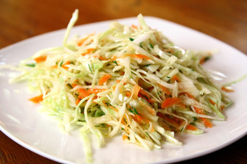 fresh coleslaw salad served on white plate