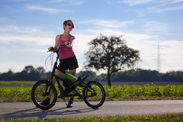 Fototapeta na wymiar sportliche Frau mit Streetstepper und Sonnenbrille