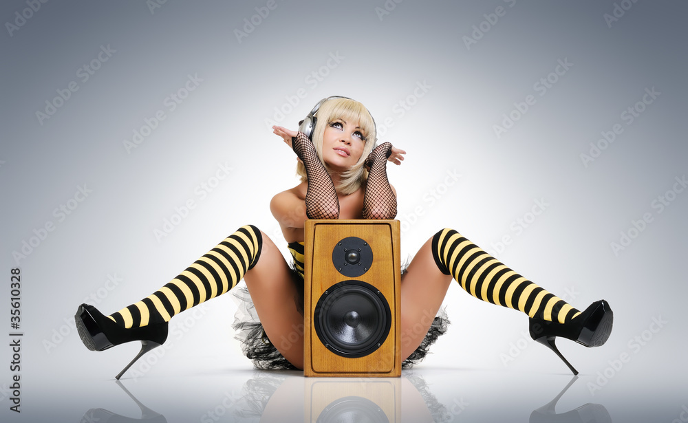 Wall mural glamour sexy young girl in headphones with speaker