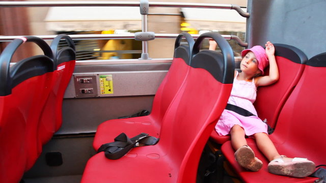 Little girl rides on open top floor of bus at streets Rome