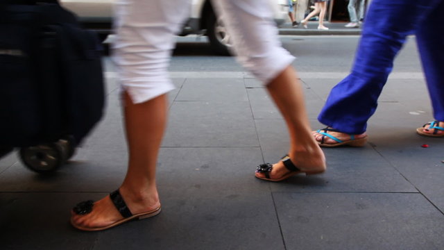 People legs and stroller walk on sidewalk