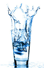 Ice cubes splashing into glass of wate