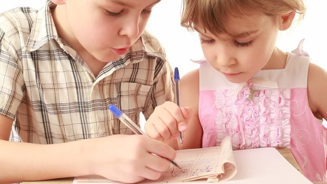 Brother and sister draw something in notebook