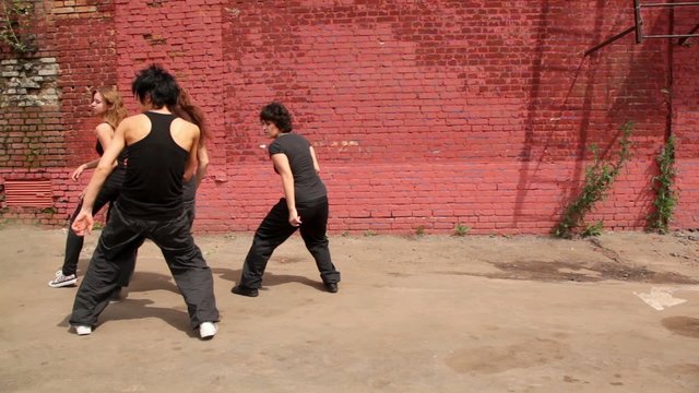 Dance team of four girls dance synchronously