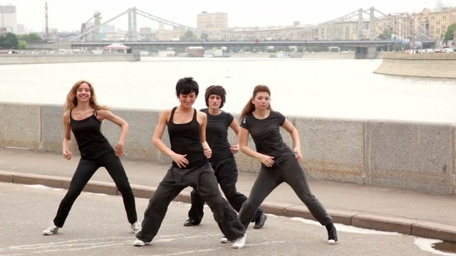 Four girls start dance in modern style synchronously on quay