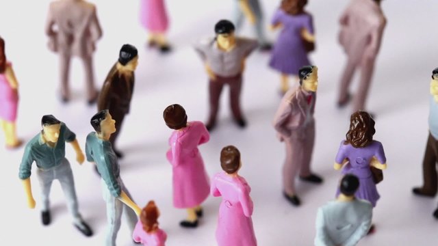 Some painted toy men and women stand in jumble