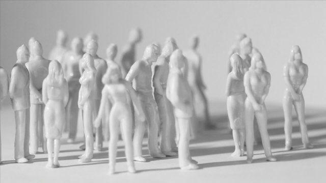 Little uncolored toy men and women stand