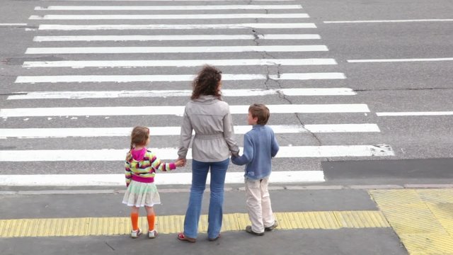 Mother and children, stand and wait to cross road