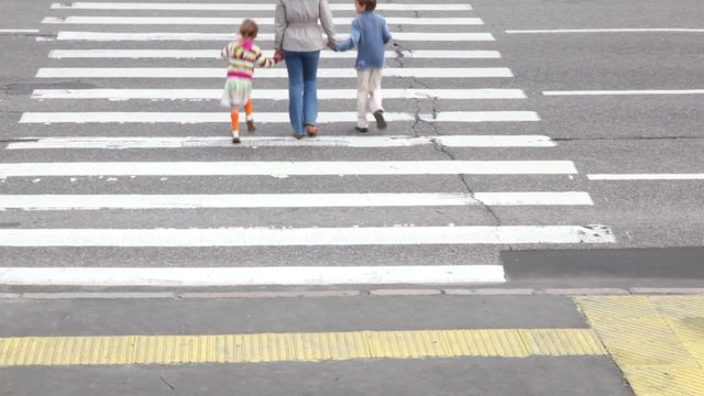 Mother and children, cross road at pedestrian crossing