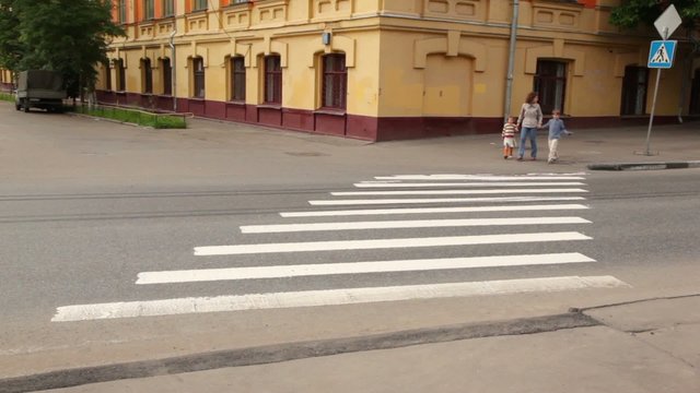 Family are at pedestrian crossing road behind them on road