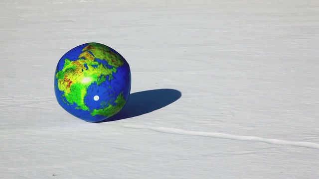 Inflated ball with earth texture roll by snow