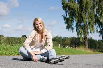 Inline skates young woman sitting asphalt road