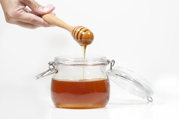 Honiglöffel mit frischem Honig von einer Hand gehalten