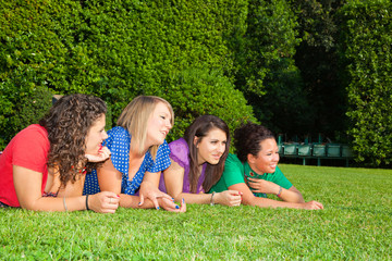 Fototapeta premium Teenage Female Friends Lying on Green at Park