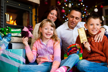Fototapeta premium Weihnachten - Familie mit Geschenken am Weihnachtsabend