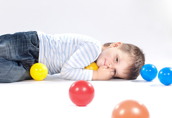 Fototapeta premium Portrait of a happy little adorable boy lying on floor and playi