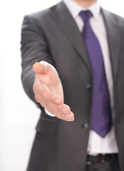 businessman extending open hand to shake against white