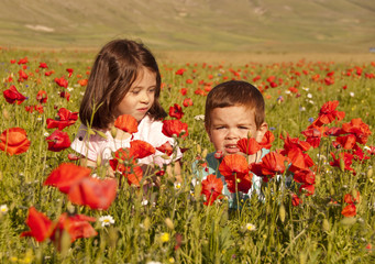 Children playing among field of flowers
