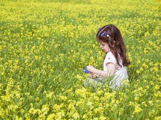 Girl playing among field of flowers