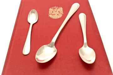 Threes silver spoons on red