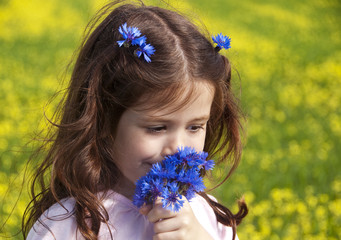 Naklejka premium Girl sniffing cornflowers