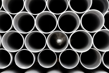 gray PVC tubes plastic pipes stacked in rows
