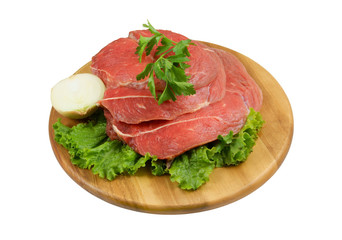 Raw beef meat with fresh vegetables on wooden cutting board