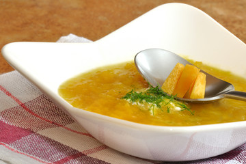 zupa z dyni w białym talerzu  na serwetce