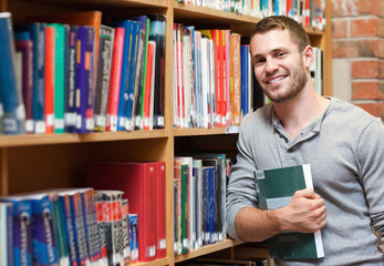 Smiling male student holding a book