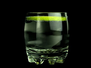 Drink and lime slice on black black background