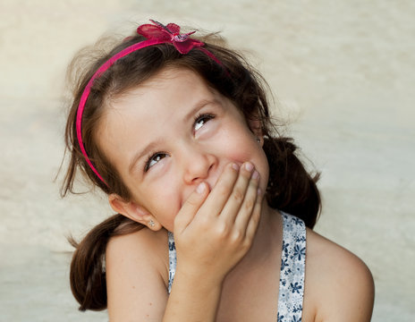 Smiling girl closing her mouth with her hand