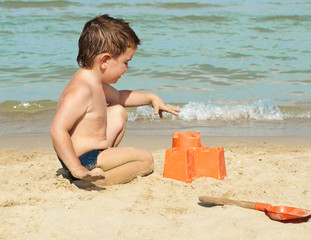 Child building a sand castle on the beach