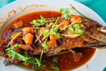 Fried grouper fish with sauce,sour and spicy on white plate,Thai