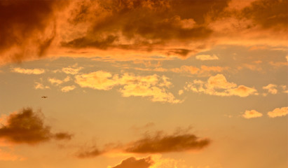 Aeroplane flying through dramatic sunset