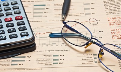 Periódico con calculadora y gafas