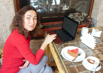 A young attractive woman sitting in a cafe with a laptop