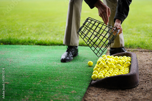 Yellow golf balls pouring out of basket