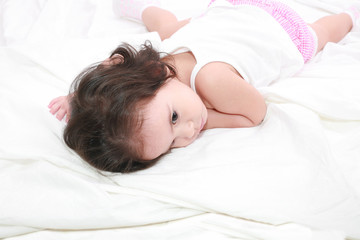 adorable toddler girl on the bed at home