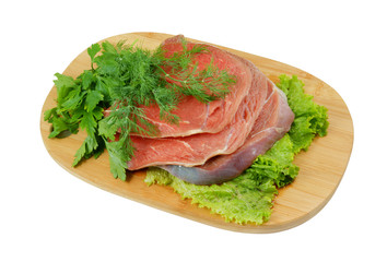Raw beef meat with greens on cutting board
