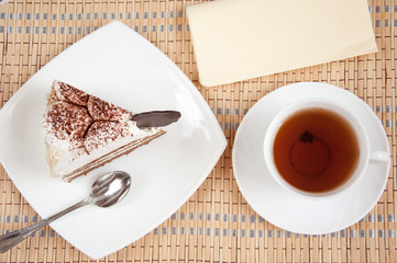 Tea and a slice of cake with cream
