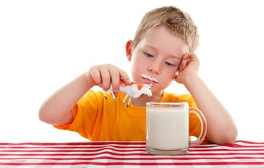 Young kid playing with toy cow behind glass of milk