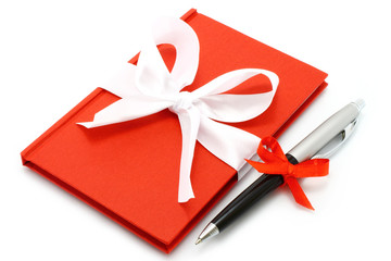 Notepad with white bow and pen © rvlsoft