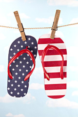 Flag patterned flip flop shoes hanging on clothes line