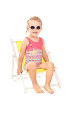 Sweet little girl on yellow deck chair