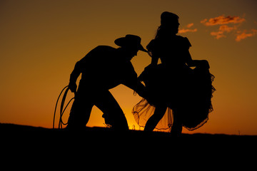 Cowboy couple silhouette grab