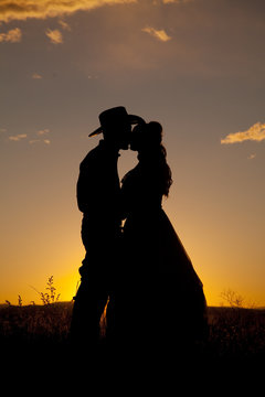 Cowboy couple silhouette kiss