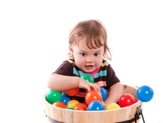 Fototapeta na wymiar fillette de 15 mois jouant avec des balles colorées