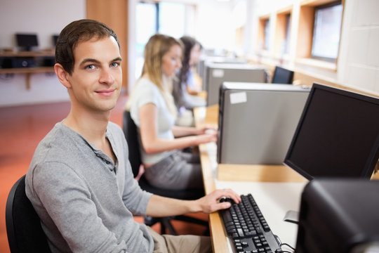 Smiling male student posing with a computer